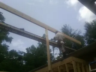 Carpenter setting a ridge beam over a new addition frame — Ice Dam Removal by Roofing Brothers in Dora