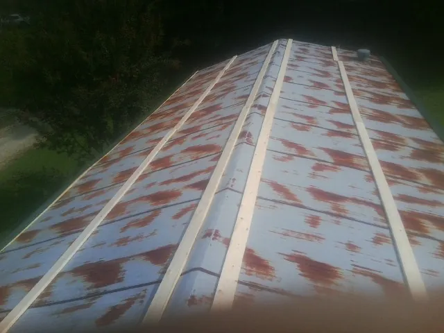 Rusted metal roof panels with new wood purlins before replacement — Storm Damage Roof Repair in Dora by Roofing Brothers